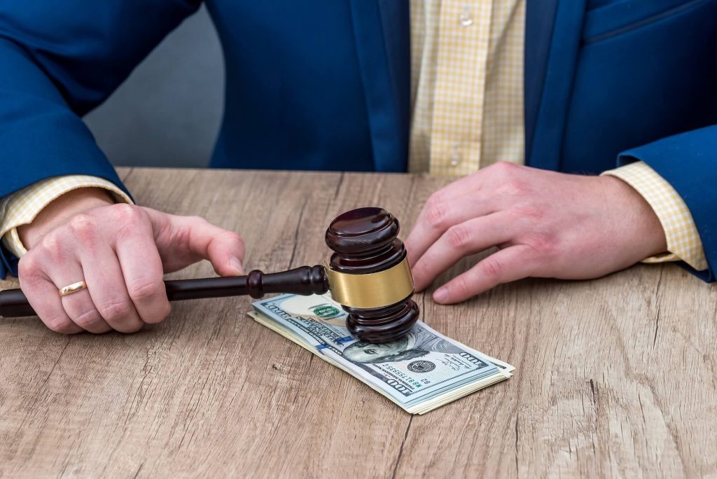 A lawyer sits at a table on which lies the money paid for his divorce services.